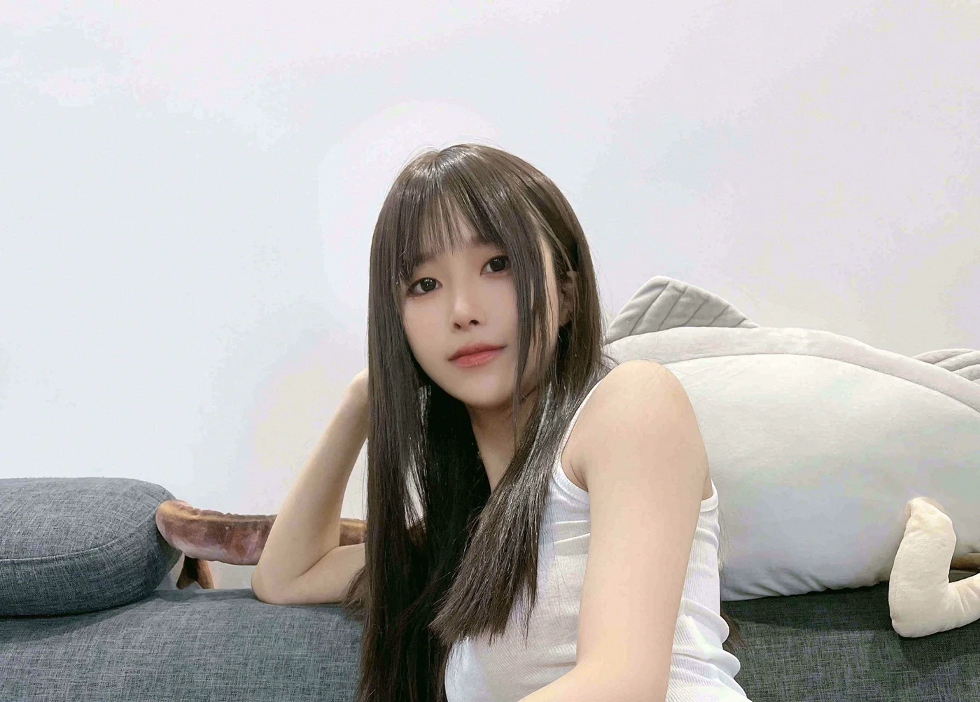 灰色沙发上的白背心侧坐近景与手臂姿态